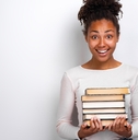 Young African American woman holding a stack of books 