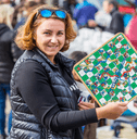 Smiling woman holding up board game