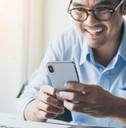 Smiling Asian man holding cellphone