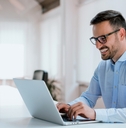 Young man sitting at his desk in the office with laptop