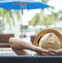 Person relaxing by hotel pool 