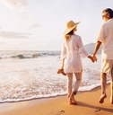 mature couple walking on the beach at sunset