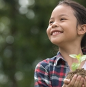Asian child holding a plant