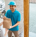 delivery man delivering food to a woman at home