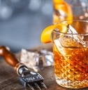 old fashioned classic rum cocktail on ice with orange zest garnish