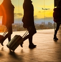 people and traveling luggage walking in airport terminal building