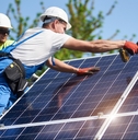 technicians installing heavy solar photo voltaic panels to high steel platform