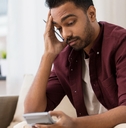 confused man with calculator at home
