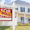 sold home for sale sign in front of new house
