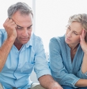 worried couple using their laptop to pay their bills