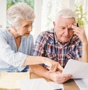 Worried senior couple checking their bills
