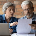 serious mature couple checking financial documents