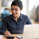 woman using a calculator and a laptop