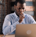 Man looking at computer and thinking