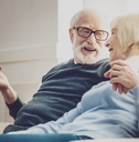 aged woman looking at her beloved man while listening to his jokes