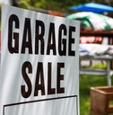Garage sale sign on the lawn of a suburban home