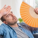 One man sweating suffering summer heatwave at home