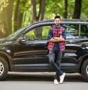 man standing in front of a black car