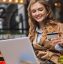 a woman smiling while looking at a credit card