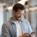 Happy young businessman using smartphone