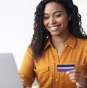 Woman looking at computer holding a credit card