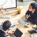 four people at a meeting studying charts