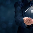 man in a black suit holding a virtual home