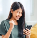 happy Asian woman looking at phone