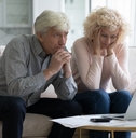 mature husband and wife frustrated about overspending family budget 