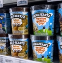 Pints of Ben &amp; Jerry&#x27;s ice cream stacked on a grocery store freezer shelf. 