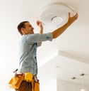 electrician is installing and connecting a lamp to a ceiling