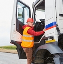 truck driver climbs into his truck with a delivery