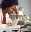  woman keeping eyes closed and massaging nose after working at laptop