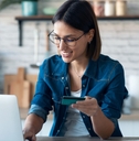 Woman holding credit card working on laptop