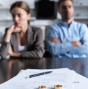 young depressed couple with divorce papers on table