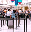 Travelers waiting in an airport security line. 