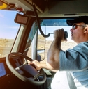 driver driving a truck white talking on radio