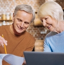 elderly man holding his notes while showing them to a pleasant aged woman