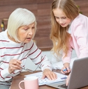 female grandchild and her granddaughter looking at the calendar