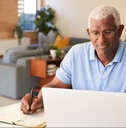 man using laptop to check finances at home