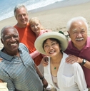 group of happy senior couples on beach