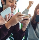 A group of people playing mobile games on their phones together. 