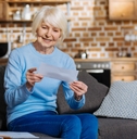 Senior woman smiling and holding a check