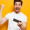a happy adult man playing a mobile game