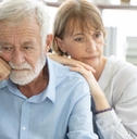 senior couple sitting on couch having each other back