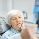 worried elder woman during the consultation with the dentist