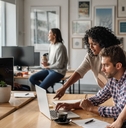 three young designers using a laptop together at work