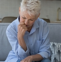 upset older woman sit on sofa manages finances