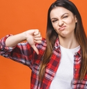 young woman wearing red flannel shirt doing thumbs down