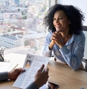 man and woman in office talking while holding cv in hand